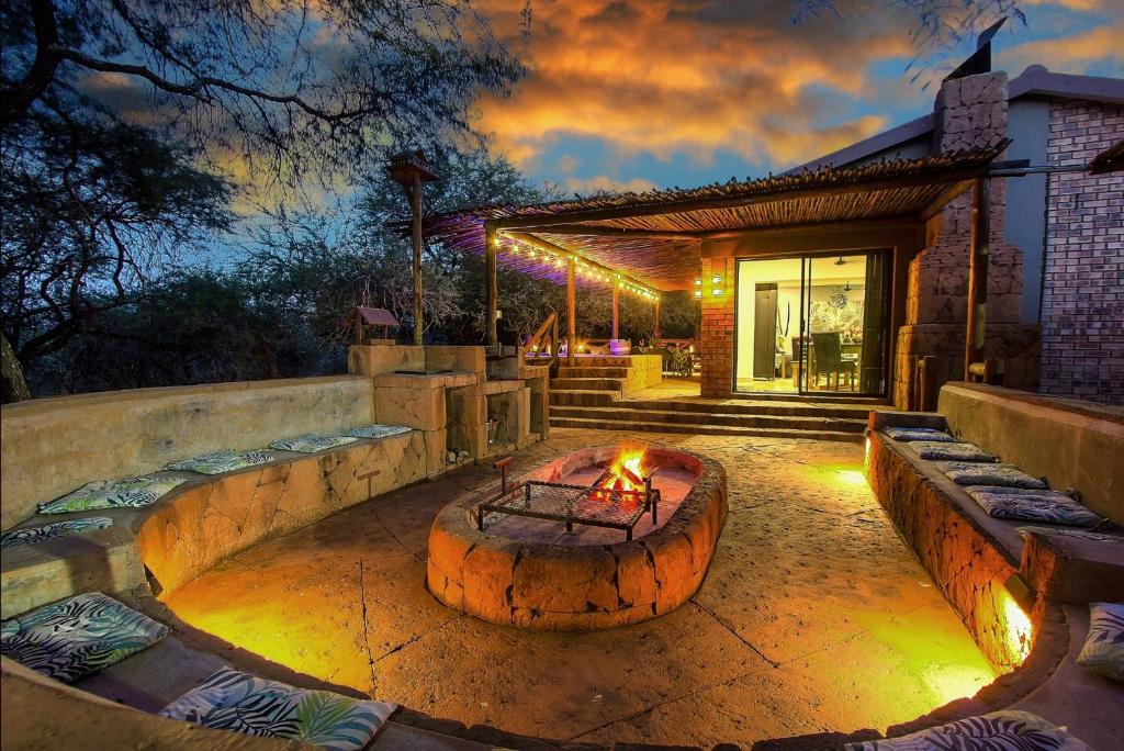 a patio with a fire pit in front of a house at Kaya KaBush in Marloth Park