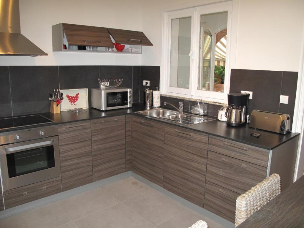 a kitchen with wooden cabinets and a counter top at Vip appartement tunis in La Goulette