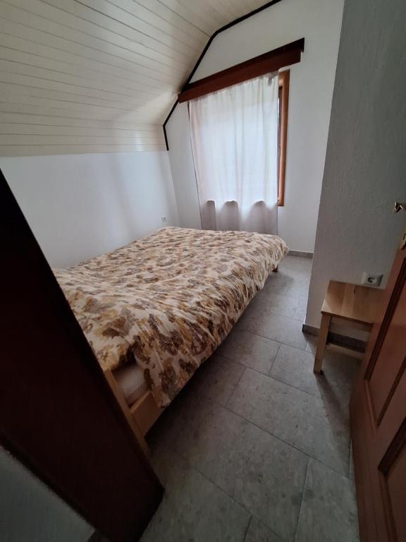 ein Schlafzimmer mit einem Bett in einem Zimmer mit einem Fenster in der Unterkunft Apartmani "DA HOX" Vlašić 2 in Vlasic