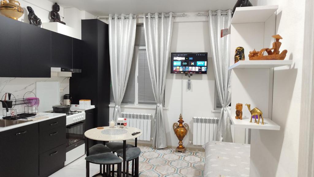 a kitchen with a table and chairs in a room at parkent plaza apartments in Tashkent
