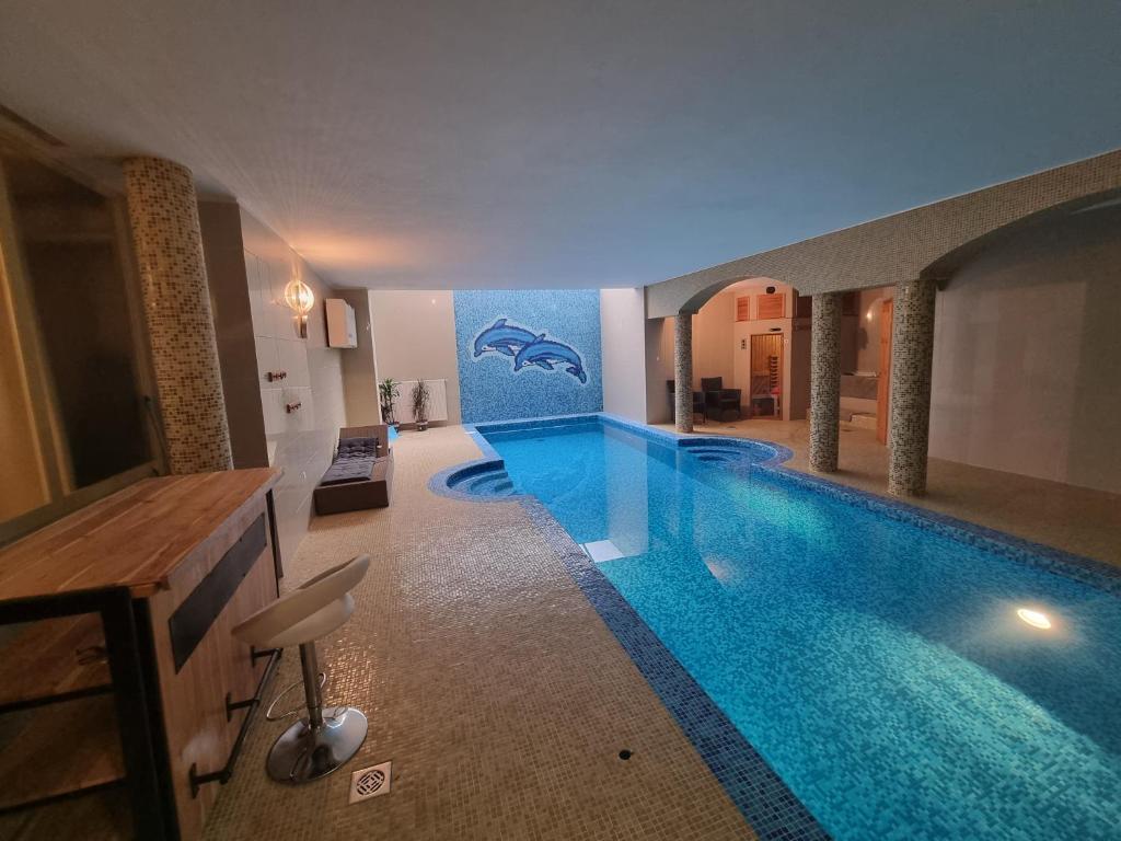 a large swimming pool in a building with a swimming pool at Relax & Wellness Villa Diósd in Budapest