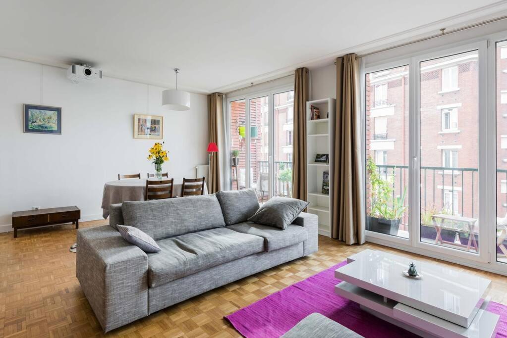 ein Wohnzimmer mit einem Sofa und einem Tisch in der Unterkunft 10 mns from Champs-Elysées, quiet in Paris