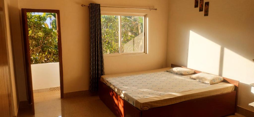 a small bedroom with a bed and a window at Comfort Family Homestay in Guwahati