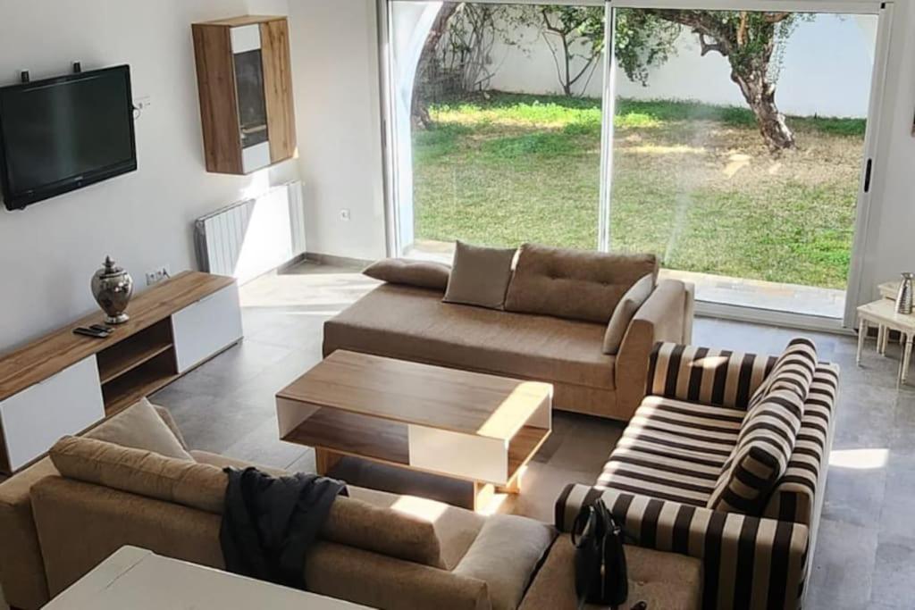 een woonkamer met 2 banken en een tv bij Villa 8 personnes Hammamet Zone Plage et Hotels in Hammamet