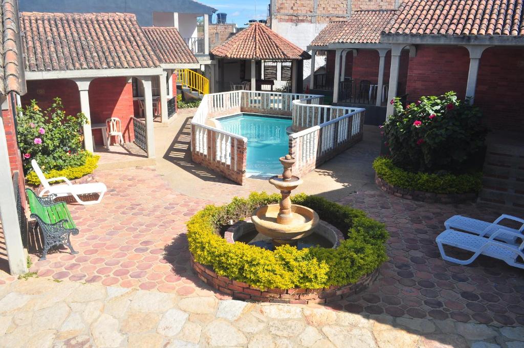 a courtyard with a fountain and a swimming pool at Hotel Aguablanca in La Mesa
