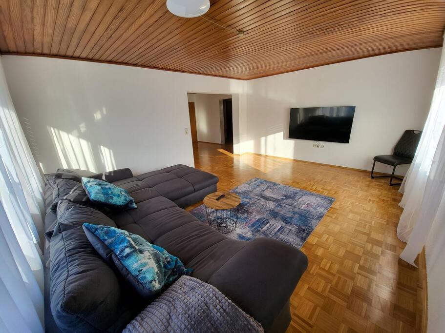 uma sala de estar com um sofá e uma televisão de ecrã plano em Zentrale, Helle Ferienwohnung em Crailsheim