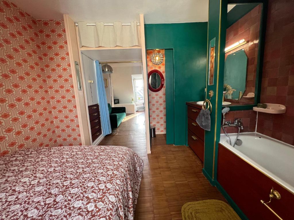 une chambre avec un lit, une baignoire et un lavabo dans l'établissement Sublime Appartement Parisien, à Paris