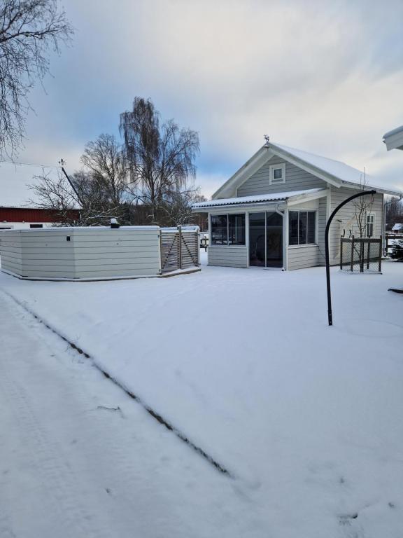 a house in the snow with a garage at Lilla Stuga in Moheda