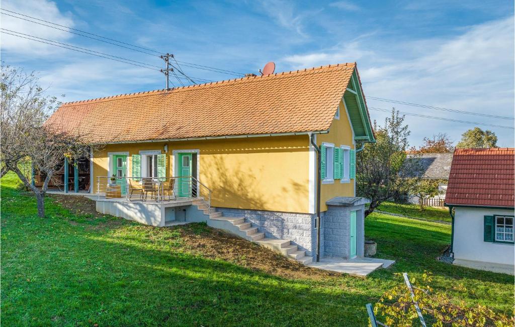 a small yellow house with a porch and grass at 2 Bedroom Beautiful Home In Eberau in Eberau