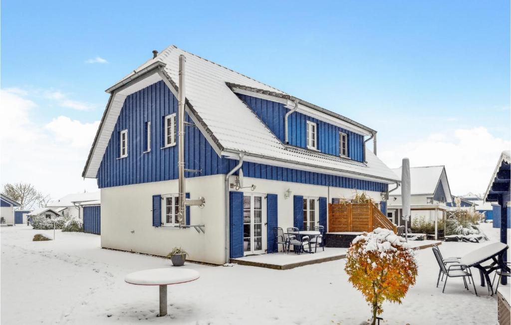アルテフェーアにあるFerienhaus 44 Altefhrの青と白の家(テーブルと椅子付)