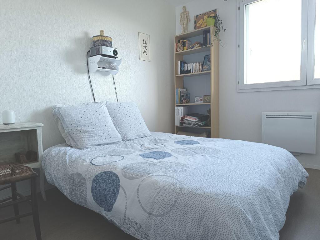 Un pat sau paturi într-o cameră la Chambre calme dans un appartement lumineux