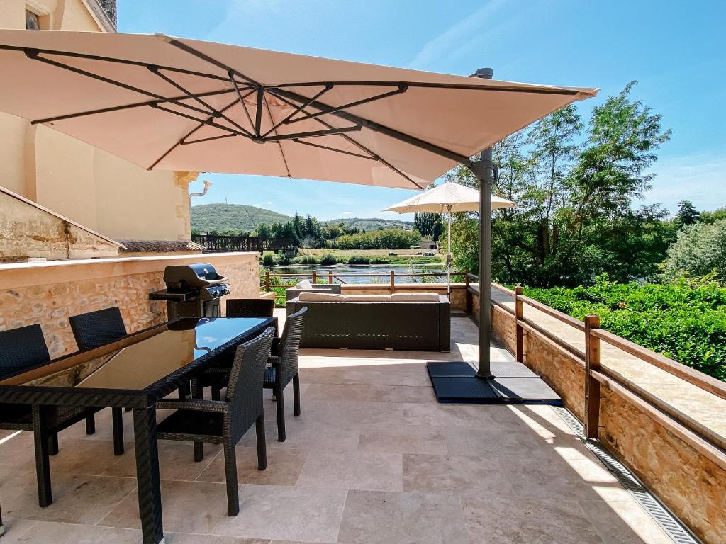 a patio with a table and an umbrella at L'Enea Terrasse in Saint-Cyprien