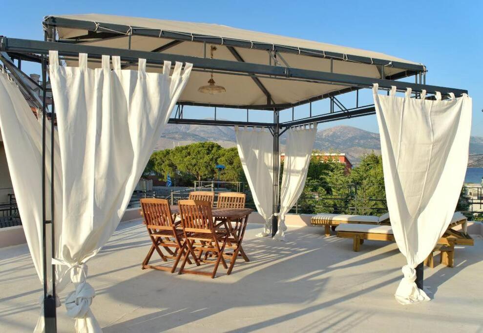 patio con tavolo e sedie sotto un baldacchino di Villa Hara, Lixouri, Kefalonia a Lixouri