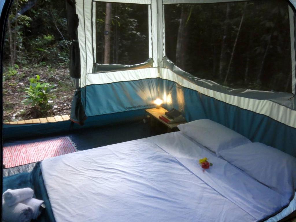 a bed in a tent with a window at YbYmara Eco Glamping in Serra Grande