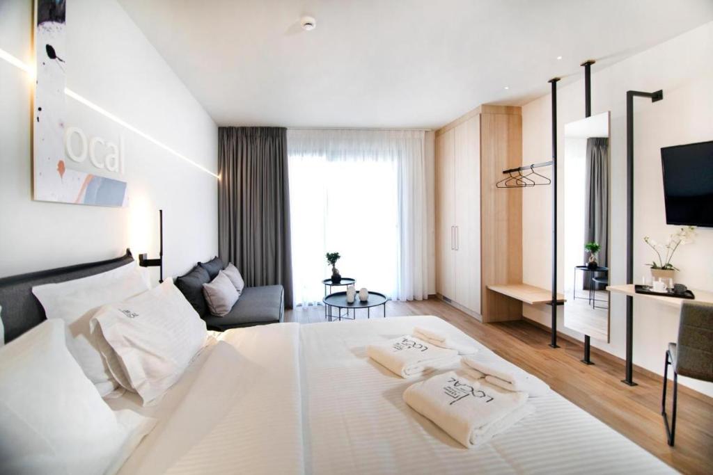 a bedroom with a large white bed with two pillows at Local Urban Living in Volos