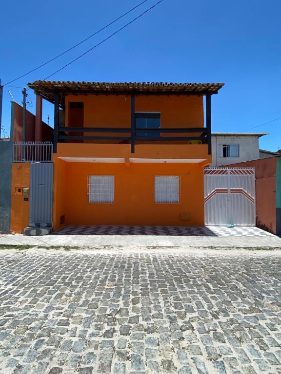 an orange house on a cobblestone street at casa grande e tranquila in Porto Seguro