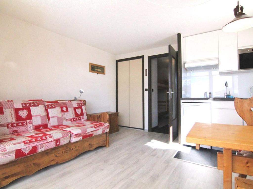 ein Wohnzimmer mit einem Bett und eine Küche in der Unterkunft Appartement Huez, 1 pièce, 4 personnes - FR-1-405-108 in L'Alpe-d'Huez