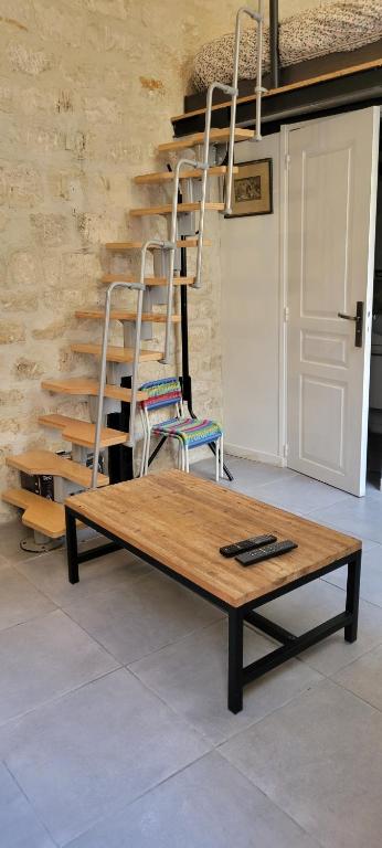 uma mesa de madeira com um banco e uma escada em Studio Marais Ménilmontant em Paris
