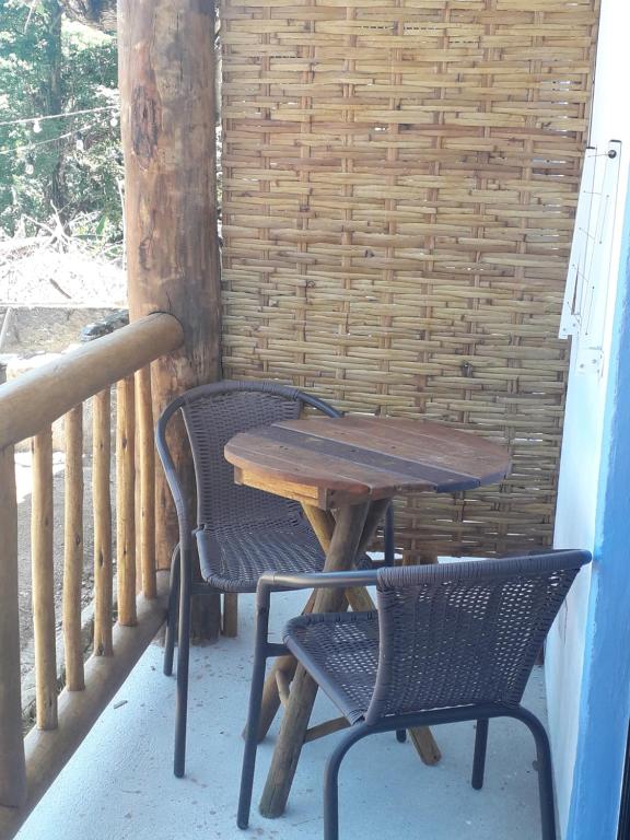 a wooden table and two chairs on a porch at Good Vibes in Ilhabela