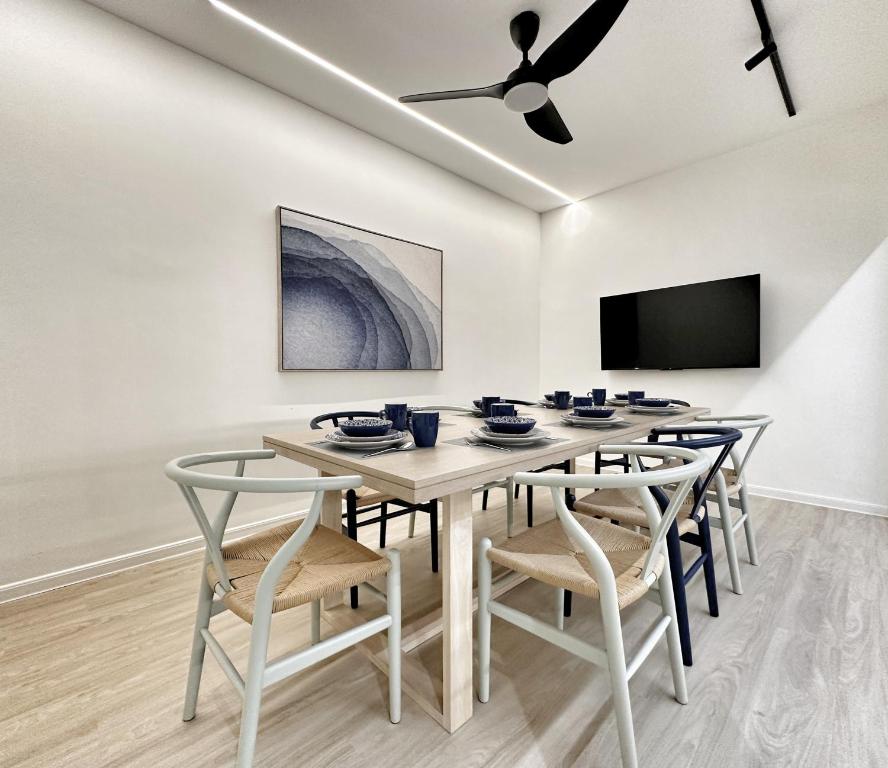 a dining room with a table with chairs and a ceiling fan at Designer Guesthouse Pulau Tikus & Gurney Drive, Georgetown, Penang in George Town