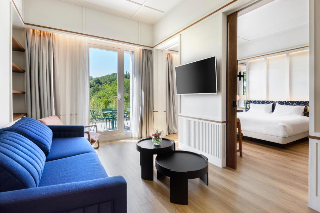 een woonkamer met een blauwe bank en een tv bij Hotel Tres Reyes San Sebastián in San Sebastian