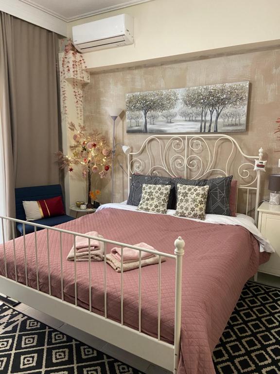 a bedroom with a large bed with a pink blanket at Zoi's central home in Volos