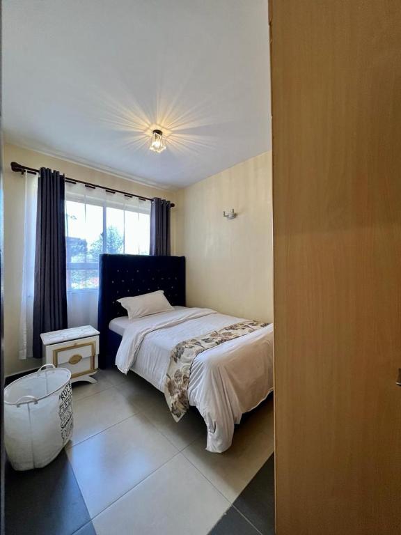Schlafzimmer mit einem Bett und einem Fenster in der Unterkunft Paradise palace in Nairobi