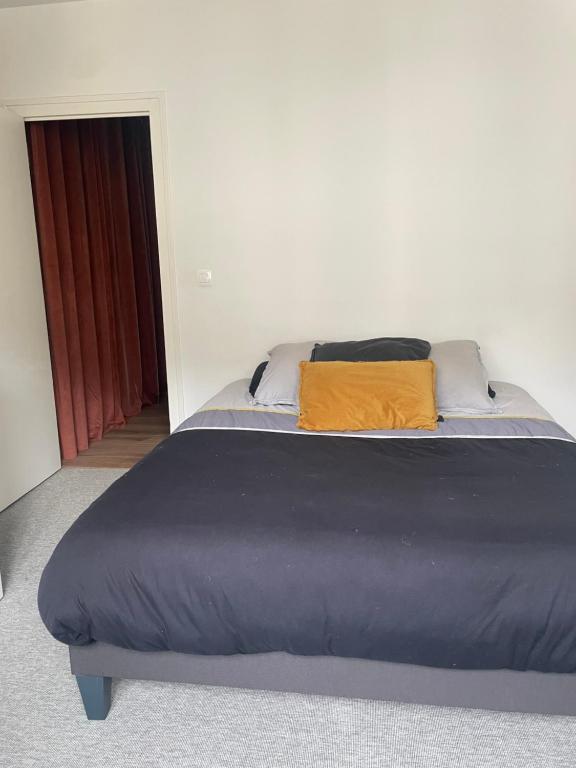 a bed with two pillows on it in a room at Superbe appartement haut de gamme centre ville in Le Mans