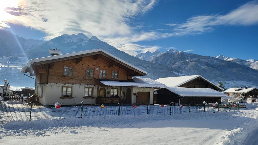 een huis in de sneeuw met bergen op de achtergrond bij Haus Alpenliebe in Piesendorf