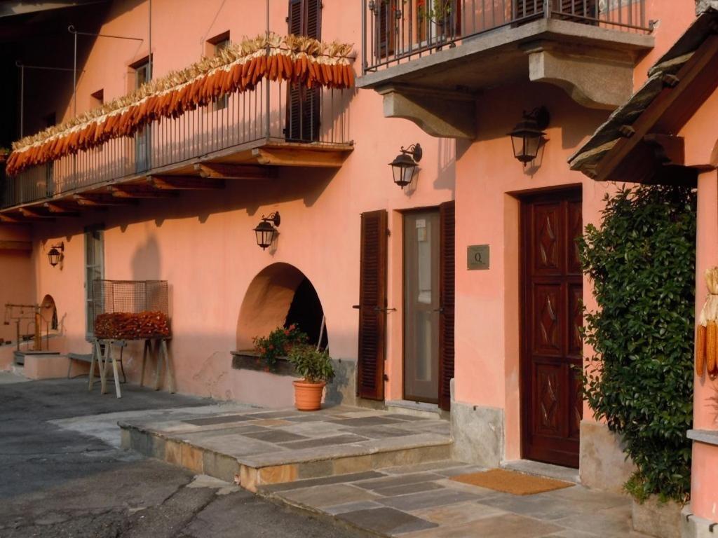 a pink building with a door and a balcony at B&B Il Mulino in Sanfront