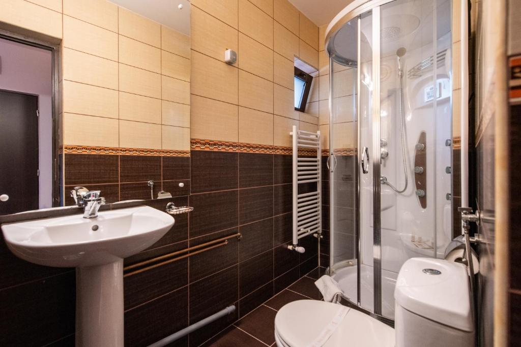 a bathroom with a sink and a toilet and a shower at Hunter Vip in Reghin