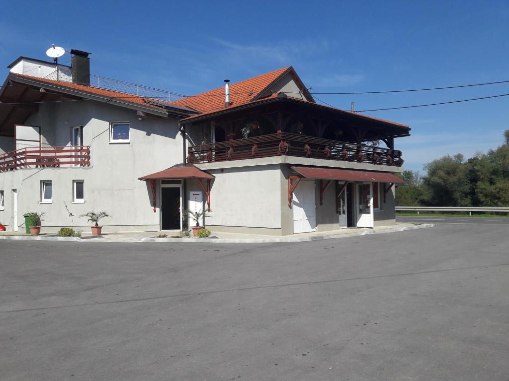 a large white building with a balcony on a street at Guesthouse Kod mosta in Karlovac