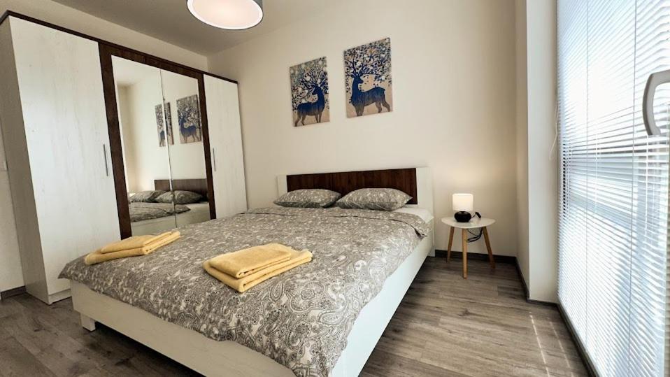 a bedroom with a bed with two towels on it at Lucky Homes Apartment Kosice in Košice