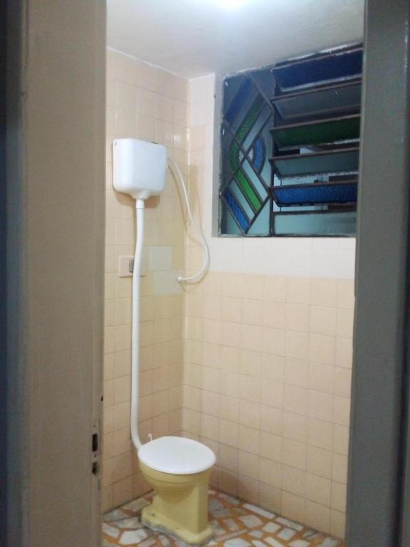 a bathroom with a toilet and a painting on the wall at Ninho do pelicano in Fortaleza