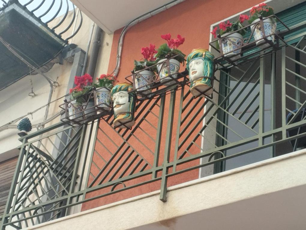 un balcón con macetas de flores en un edificio en AurHouse, en Castel di Iudica