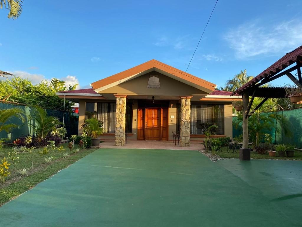 uma casa com uma entrada verde em frente em Casa Brisa Marina, Comfy Villa for 7 with Private Pool, Just 10 Minutes from Manuel Antonio! em Quepos