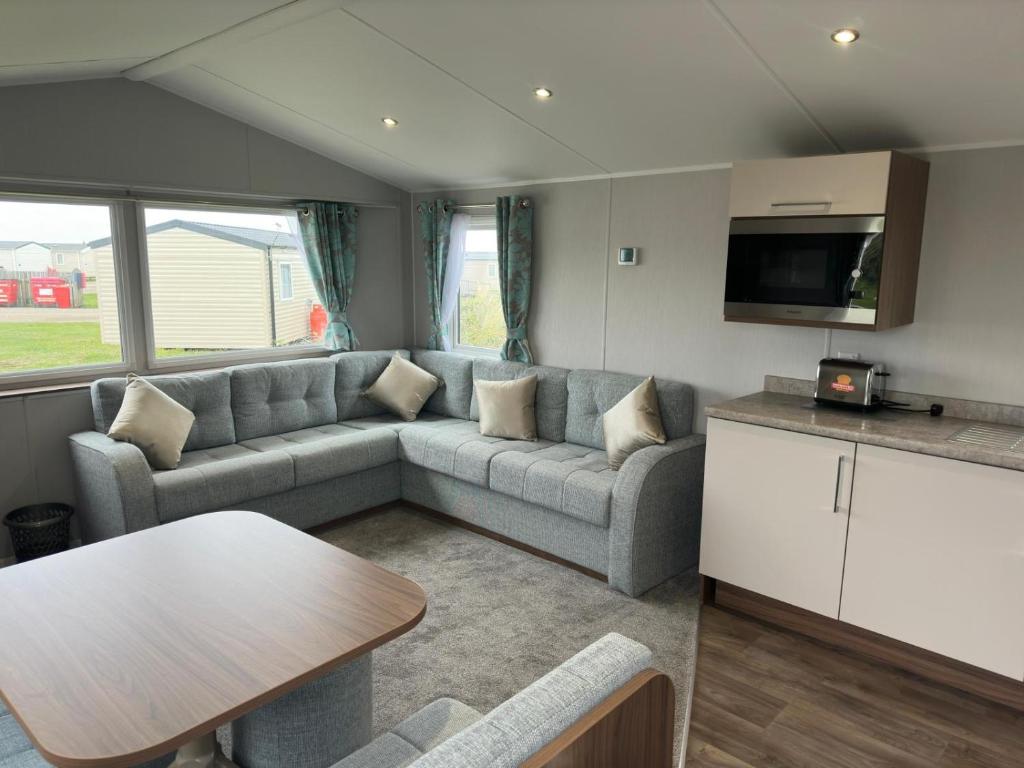 a caravan living room with a couch and a table at Perranporth Holiday Park in Perranporth