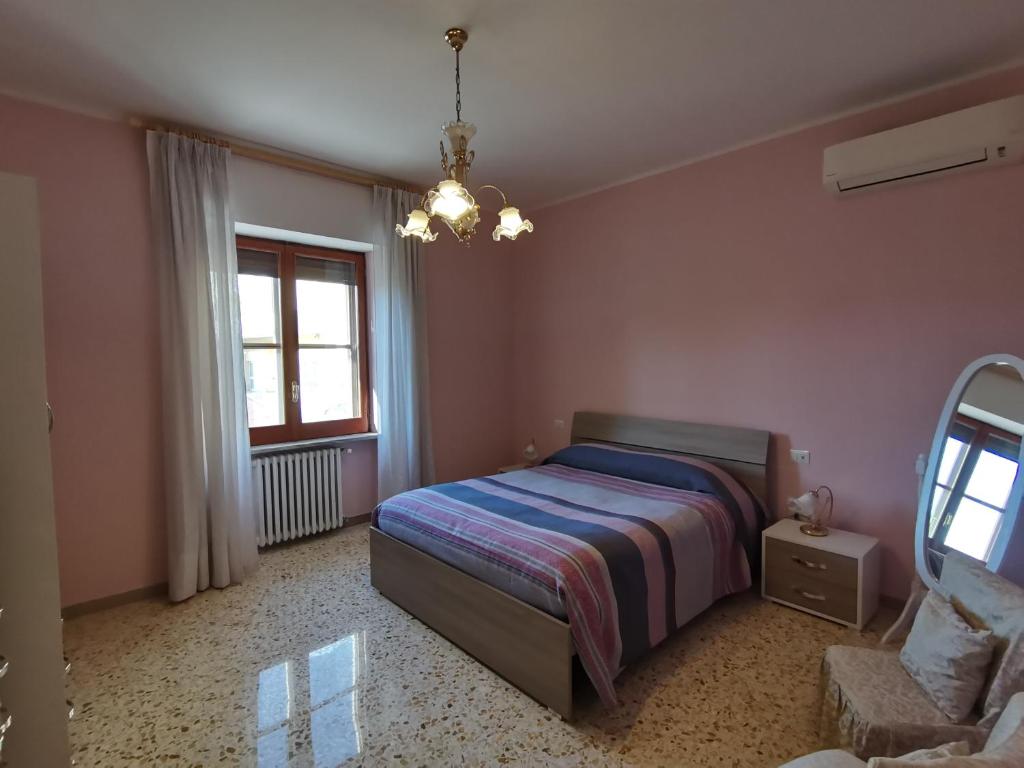 een slaapkamer met een bed, een raam en een kroonluchter bij Domus Lineker in Venafro