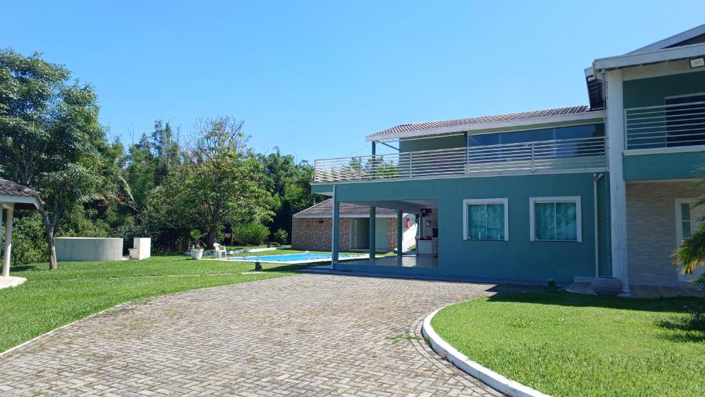 a house with a patio and a driveway at Sitío Paraíso in Jambeiro