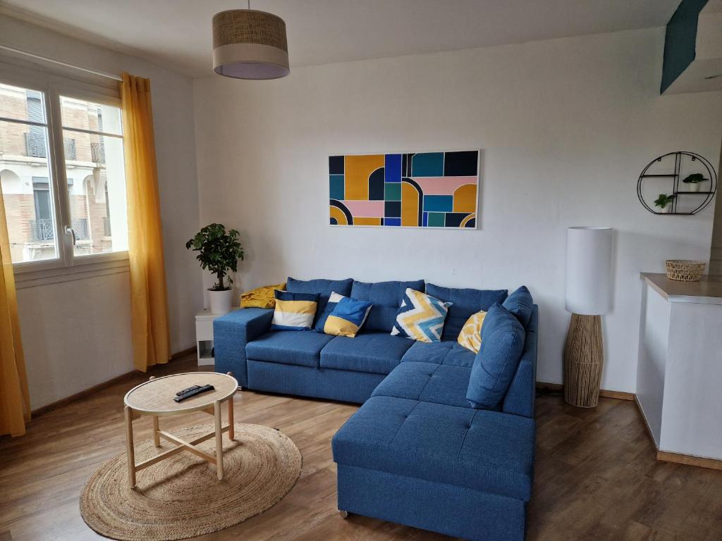 a living room with a blue couch and a table at Grand appartement cosy-Hyper Centre-Place Verdun in Tarbes