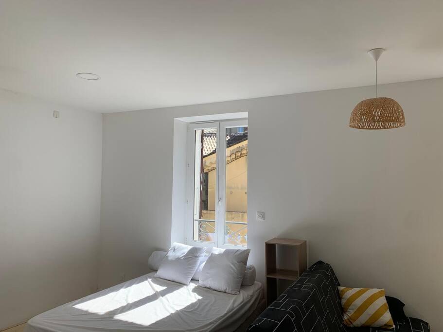 een witte kamer met een bed en een raam bij Studio 30m2 3 pers centre village in Bessèges