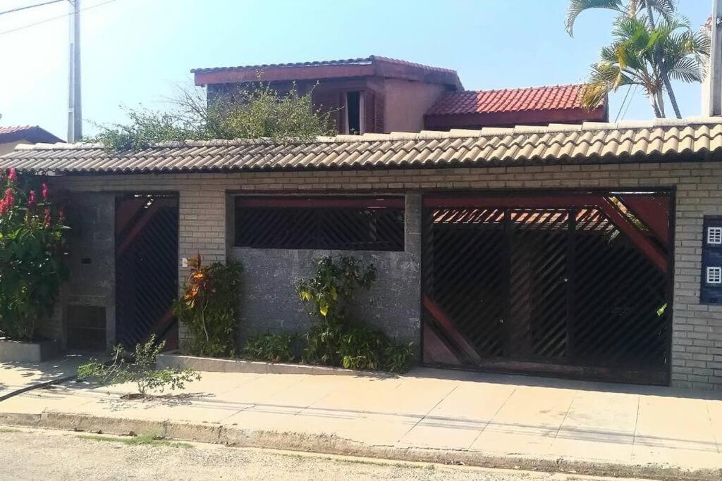 a brick building with two garage doors with plants at Hospedagem San Gonzales Two in Sorocaba