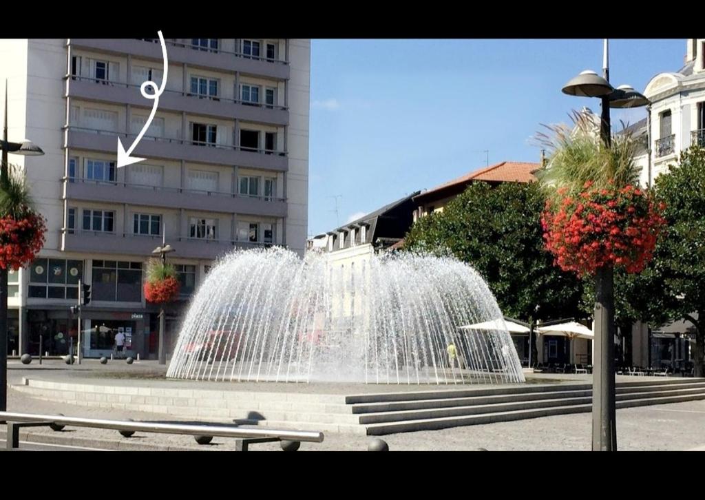 a fountain in the middle of a city with a building at Grand appartement cosy-Hyper Centre-Place Verdun in Tarbes
