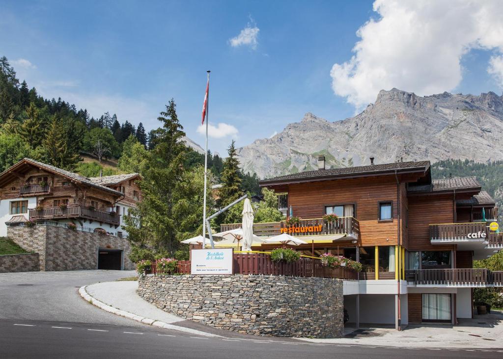 ein Gebäude mit einem Berg im Hintergrund in der Unterkunft Hôtel Restaurant de l'Ardève & Chalet Kalbermatten in Chamoson