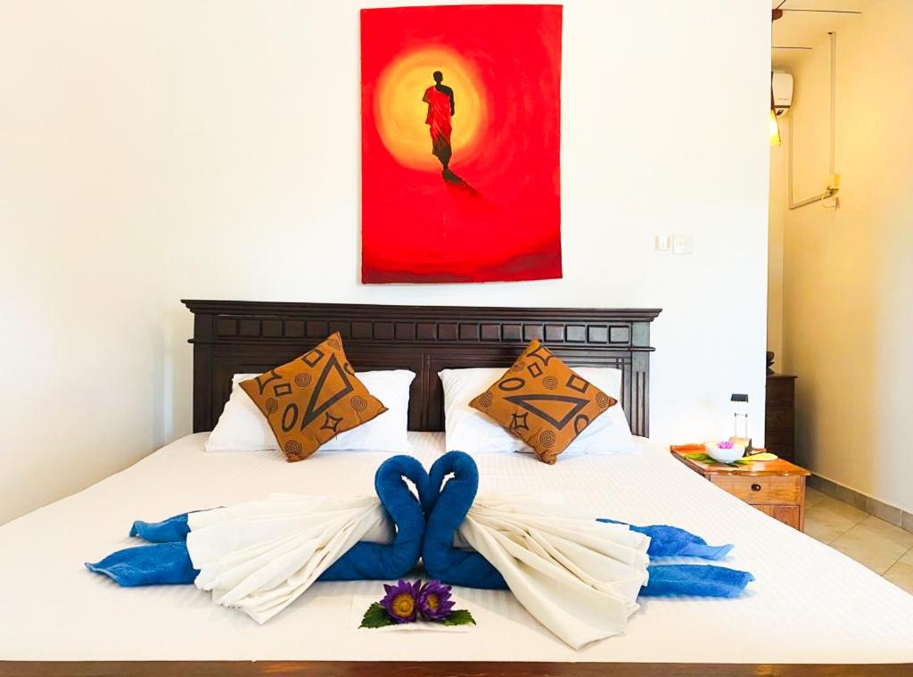 łóżko z dwoma niebieskimi łukami w obiekcie Bay Street w mieście Beruwala