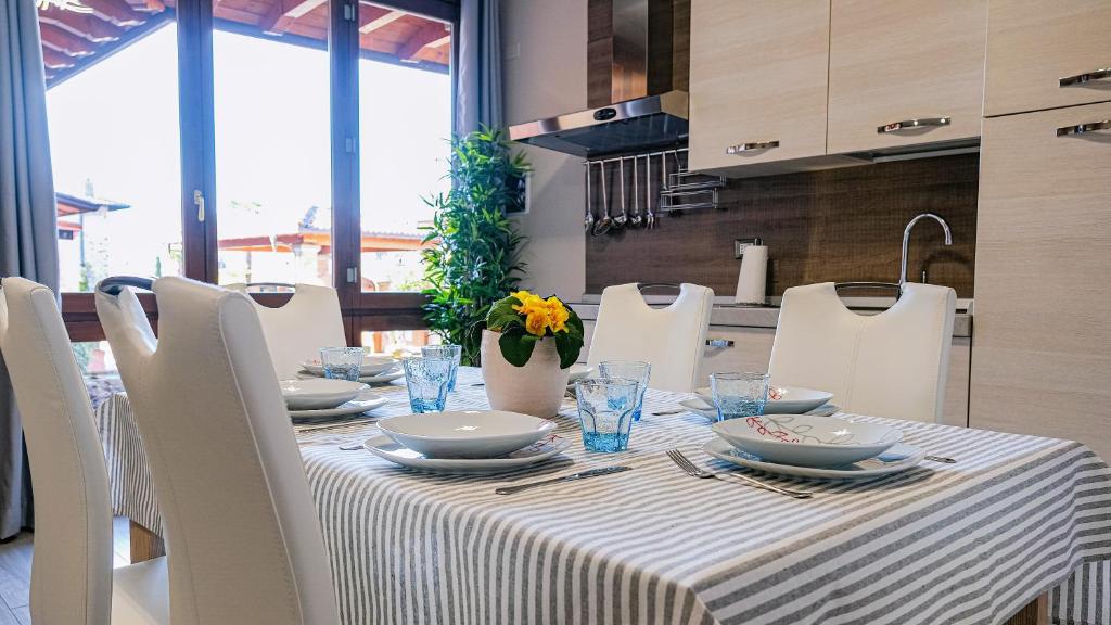 a table with white chairs and a table with a table cloth at La Corte Del Bona - vicino alle Cantine e a circa 15 minuti dal Lago di Iseo - in Erbusco