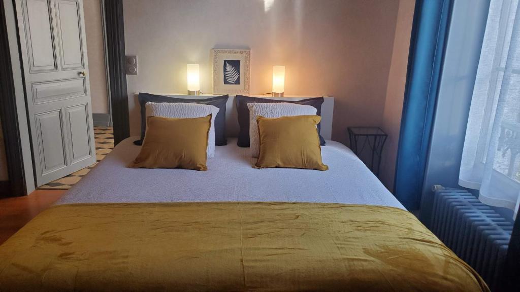 um quarto com uma cama grande e 2 almofadas em La Rossignolerie - La familiale Vigneronne em Chouzy-sur-Cisse