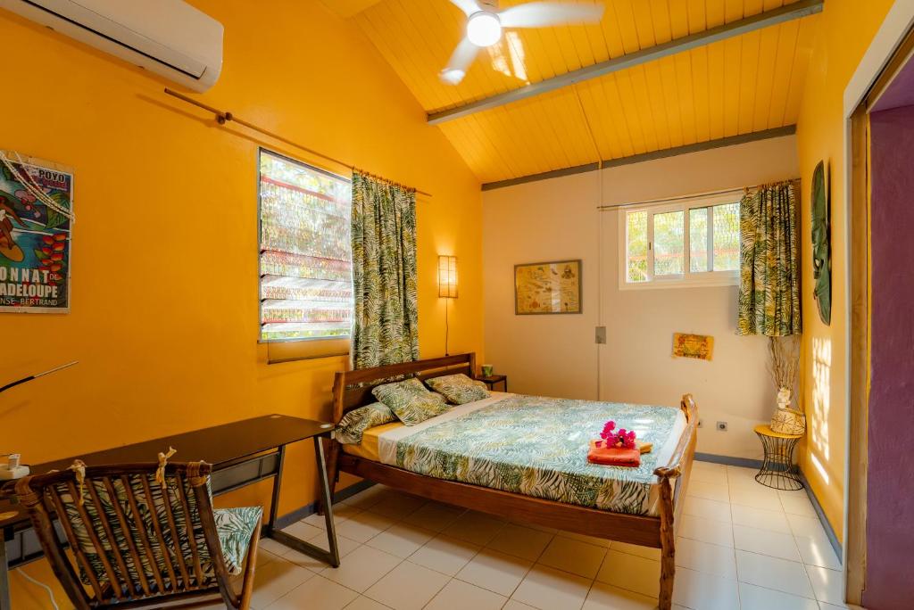 una camera da letto con un letto, un tavolo e delle sedie di Kaz Zen a Sainte-Anne