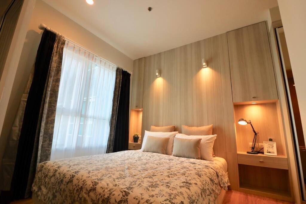 a bedroom with a large bed and a window at Condo The Zea Shiracha in Ban Bang Phra