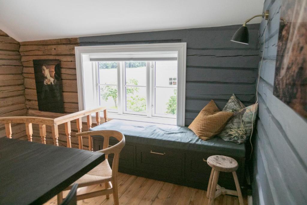 Habitación con ventana, sofá y mesa. en Østigård 1810, en Åndalsnes